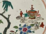 a plate with a painting of a teapot and a bird on it