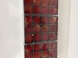 une photo d'une photo représentant une décoration de Noël rouge et dorée accrochée à un mur