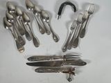 a lot of silverware on a table with a hook