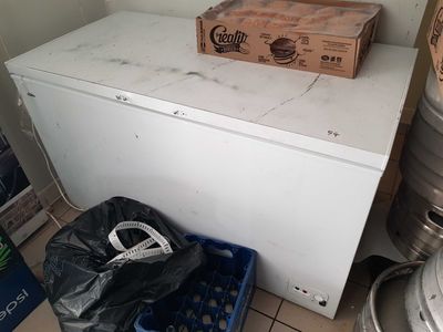 un réfrigérateur blanc dans un coin d'une pièce, avec une boîte posée dessus