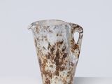 rusted metal pitcher on a white surface with a white background