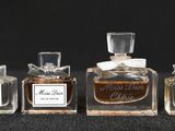 three small bottles of perfume are lined up on a black surface