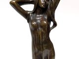 bronze statue of a woman holding her hands on her head