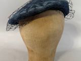 chapeau bleu marine avec de la maille, posé sur la tête d'un mannequin
