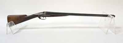 un vieux pistolet avec une crosse en bois et un étui transparent