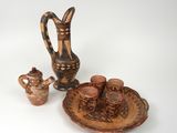 Plusieurs pièces de poterie sont exposées sur un fond blanc
