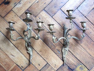 three candles that are sitting on a wooden floor