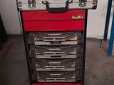 une boîte à outils rouge posée sur un chariot métallique