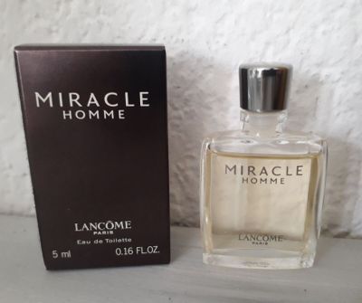 an image of a bottle of perfume next to a box