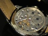 a close up of a watch on a black surface