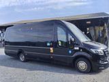 a black bus parked in front of a building