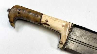 a knife that is laying on a white surface