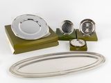 une assiette en argent et un plateau en argent posés sur une table