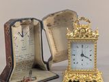 une petite horloge posée à côté d'une boîte ouverte