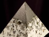 a very small pyramid with a lot of dirt on it