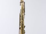 a saxophone hanging from a string on a white wall