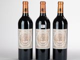 trois bouteilles de vin rouge posées côte à côte sur une table