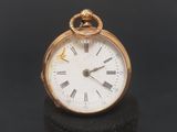 a gold pocket watch with roman numerals on the face
