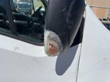 a close up of a car ' s side mirror with a car in the background