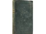 an old book sitting on top of a table on a white surface