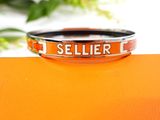 an orange bracelet with the word seller on it sitting on top of an orange box