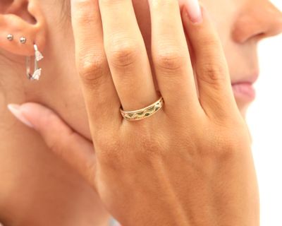 une femme qui porte une bague au doigt et une boucle d'oreille