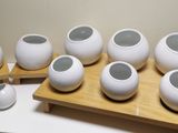 six white vases sitting on a wooden tray next to a printer