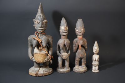 three wooden figurines of different shapes and sizes on a black background