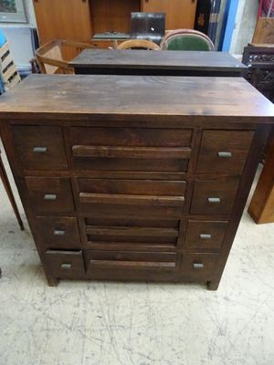 une photo d'une commode dans une pièce où se trouvent de nombreux meubles