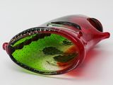 a red glass bottle with a green liquid inside of it