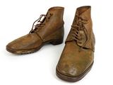 pair of brown leather boots with laces on them on a white surface