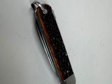 a small pocket knife with a wooden handle on a white surface