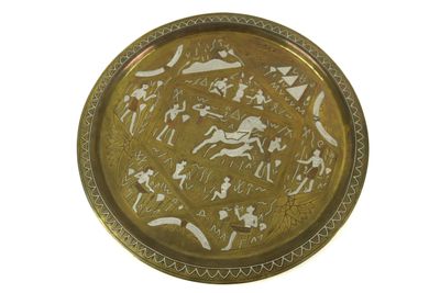 brass plate with a design of people and animals on it