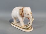 porcelain figurine of an elephant on a sled with a twig in its mouth