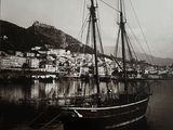 une photo en noir et blanc d'un bateau amarré dans un port