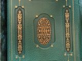 a green book with gold trim and a decorative design on it