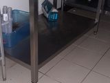 une cuisine équipée d'une table en inox et d'un évier