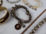 many different types of necklaces and bracelets laid out on a table
