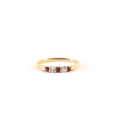 une bague en or sertie de trois pierres et d'un petit diamant