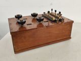 an old wooden box with four different knobs on top of it