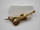 a close up of a brooch with a violin on it