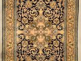 un vieux livre sur lequel figure l'image d'un tapis persan