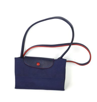 sac à main bleu marine avec une bandoulière rouge et un bouton rouge