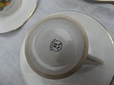 a cup and saucer sitting on a table with plates