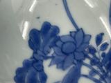 a close up of a blue and white vase with flowers on it