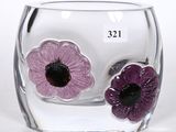 a glass vase with two purple flowers inside of it