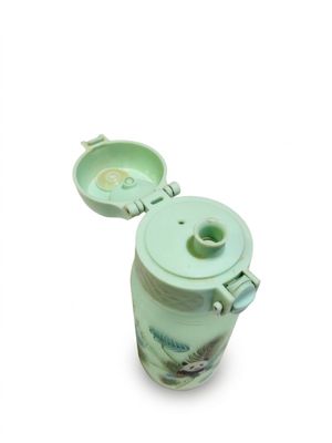 une tasse verte avec un couvercle posée sur une surface blanche