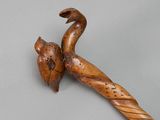 an old wooden walking stick with a bird on top of it