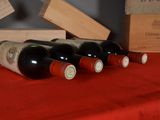 several bottles of wine are lined up on a red table cloth