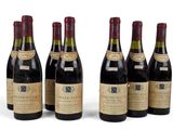 six bouteilles de vin sont alignées sur une surface blanche